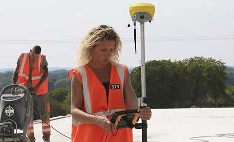 Une femme prend des mesures GPS sur un chantier